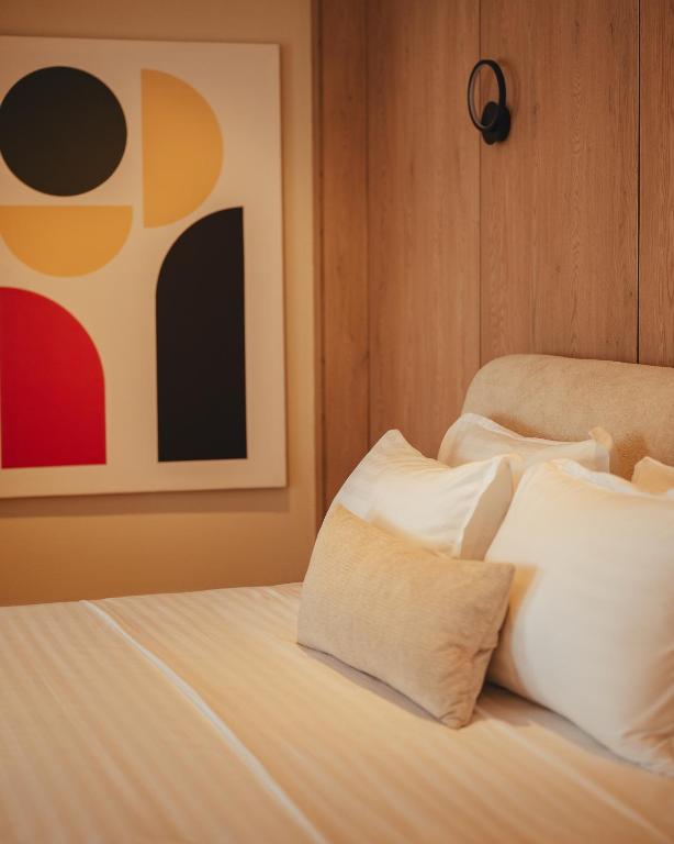 Bed detail with layered pillows and geometric artwork